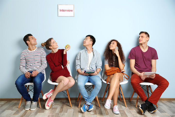 5 Bewerber sitzen auf einer Bank und warten