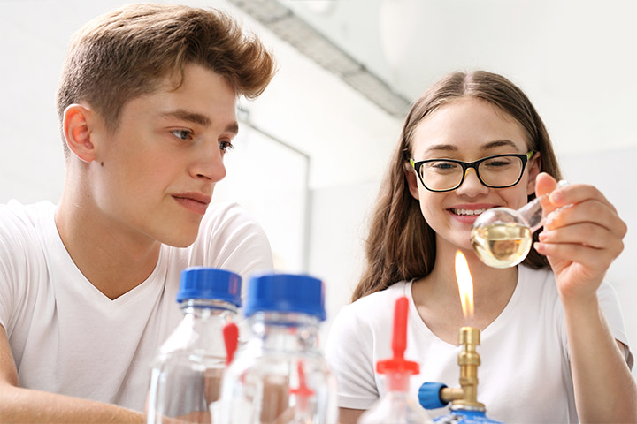 Junges Mädchen und Schüler testen in einem Labor der Glasindustrie