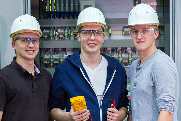 Auszubildende zum Elektroniker richten Installationssysteme ein