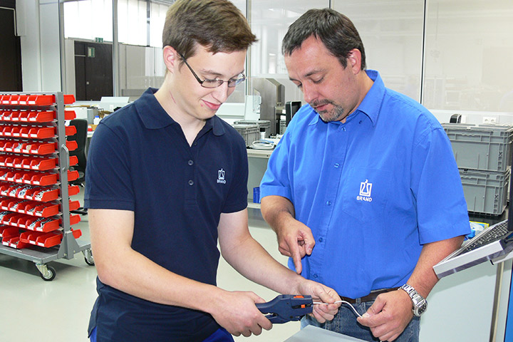 Ausbildungsleiter und Auszubildender Elektroniker in der Werkstatt.