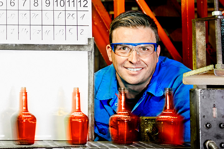 Ein Industriemechaniker prüft den Ablauf einer großen Glasproduktionsanlage